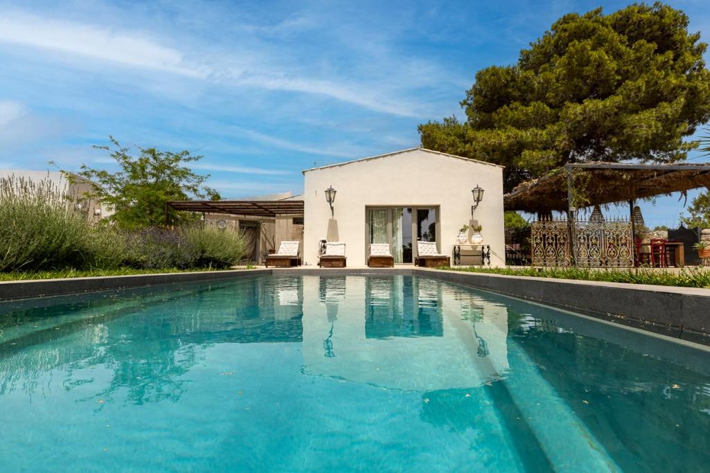 une piscine devant une maison dans l'établissement Villa Malena con piscina privata, à Noto