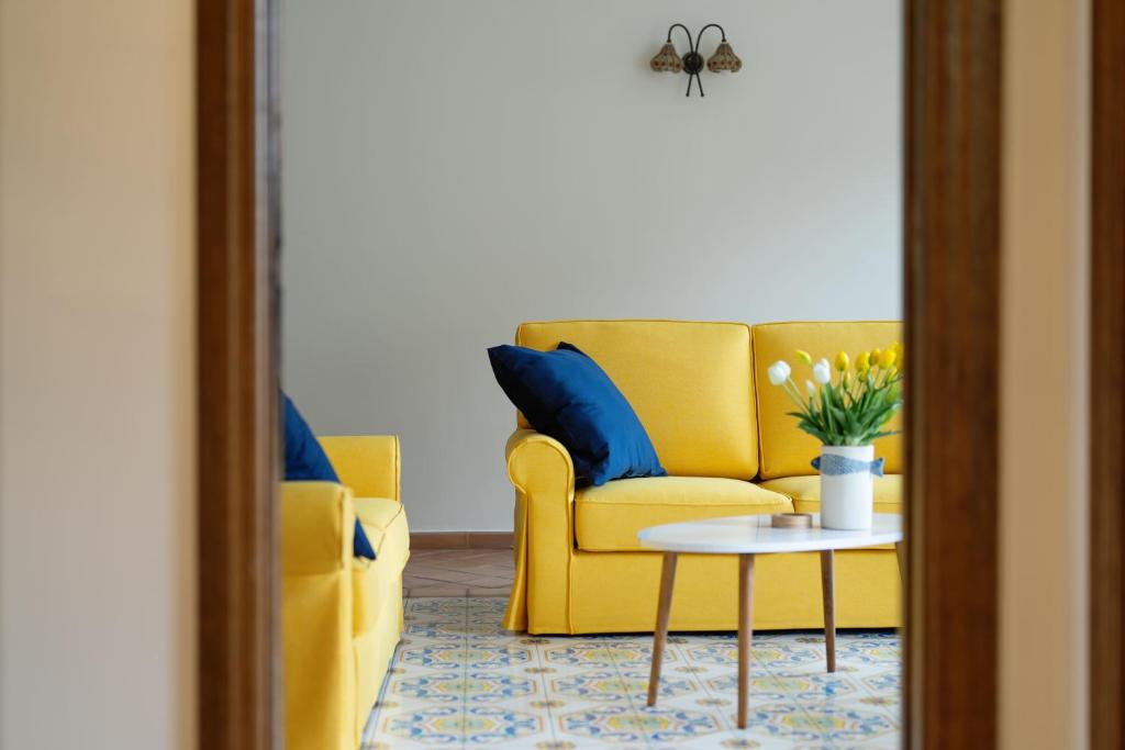 Una sala de estar con un sofá amarillo y una mesa. en Luna Guest House, en Vico Equense