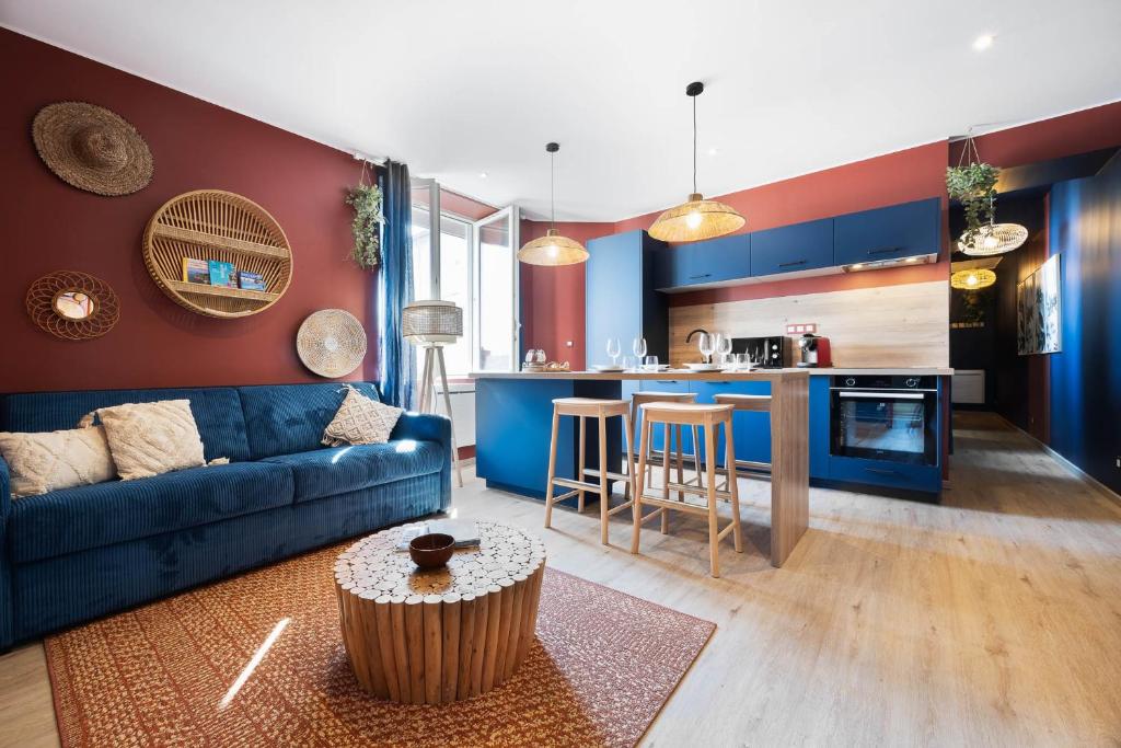 un salon avec un canapé bleu et une cuisine dans l'établissement Le terracotta T2 premium en centre bourg de Crozon, à Crozon