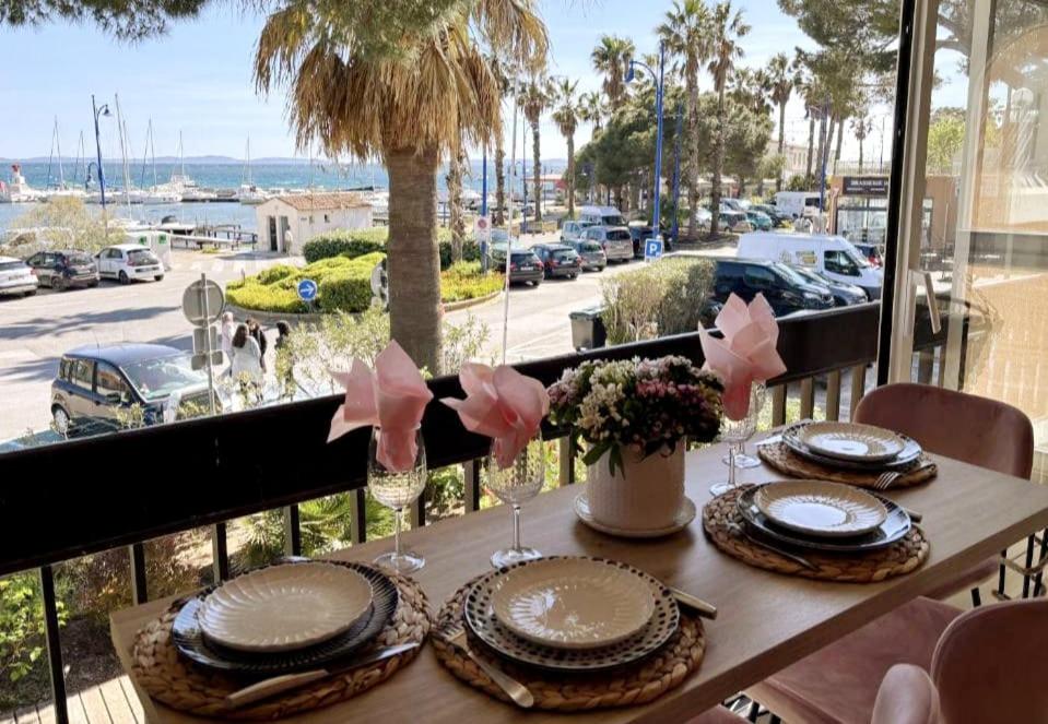 - une table avec des assiettes et des verres sur le balcon dans l'établissement Le Flamant Rose de Lilo'Salins, à Hyères