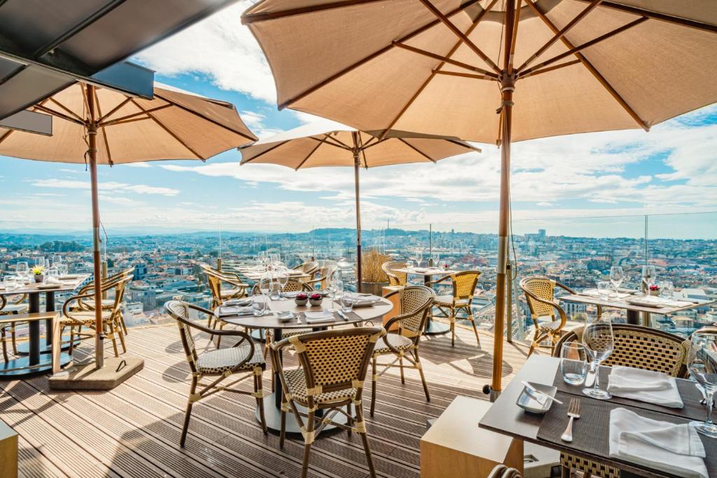 a restaurant with tables and chairs and umbrellas at Hotel Dom Henrique - Downtown in Porto