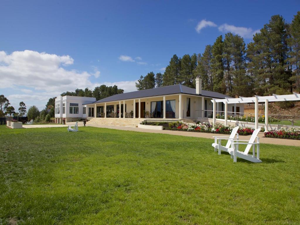 uma casa grande com um relvado em frente em Riversdale Estate Cottages em Cambridge