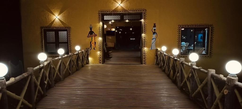 a wooden walkway leading to a hallway with lights at Somona Grandeur in Mandlā