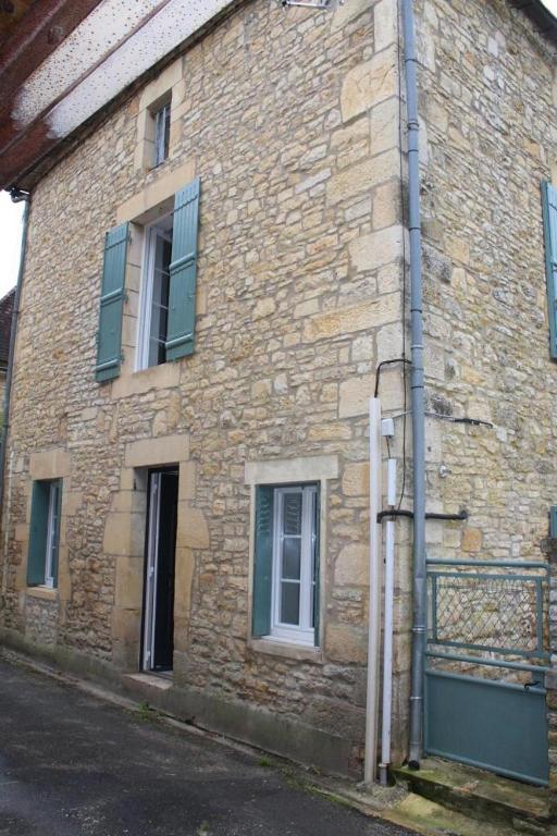un ancien bâtiment en briques avec une porte et des fenêtres dans l'établissement Rue de la levade, à Daglan