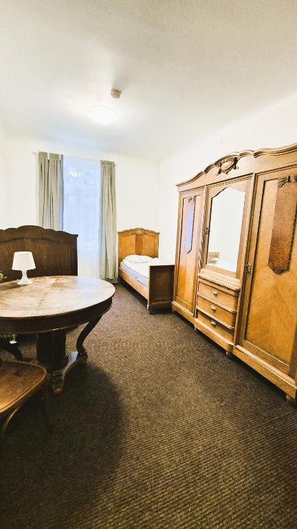 a bedroom with a bed and a table and a dresser at Riga Academic Guest House in Riga
