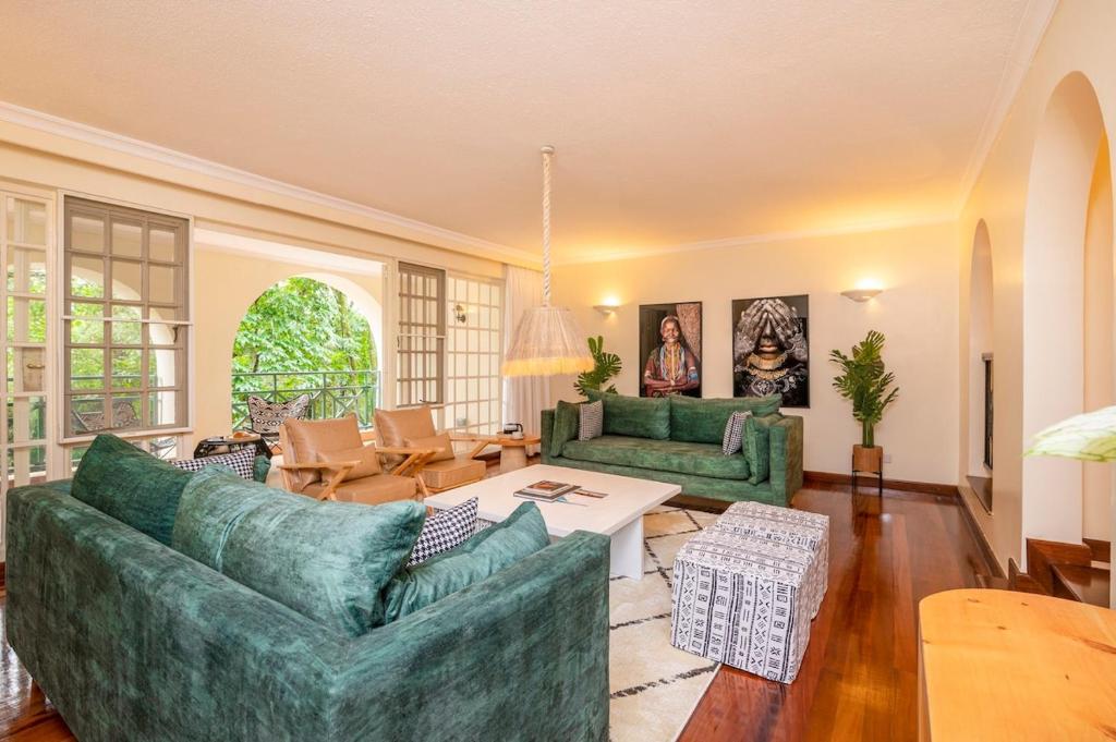 a living room with two green couches and a table at Riverside Park Complex in Nairobi
