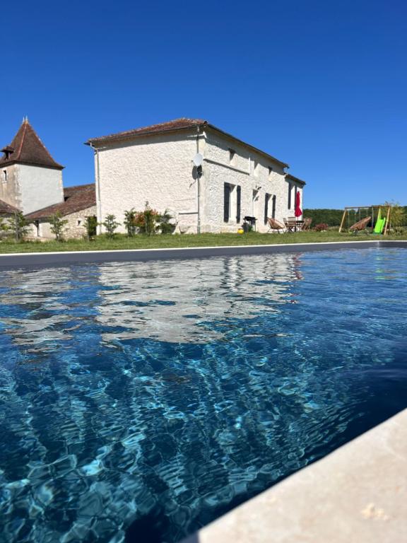 une piscine devant un bâtiment blanc dans l'établissement Domaine de Lagasse, Gîte avec Piscine, au coeur du Sud-ouest, à Hautefage-la-Tour