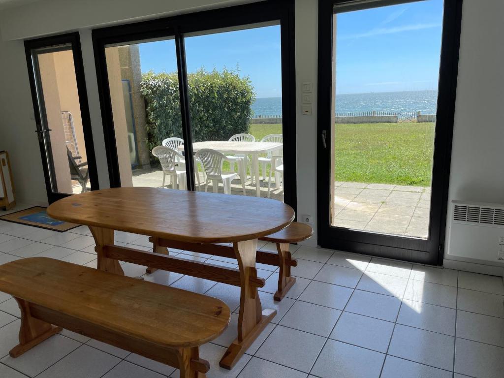une table et un banc dans une pièce avec une table et des chaises dans l'établissement appartement pied dans l'eau Bonne source, à Pornichet