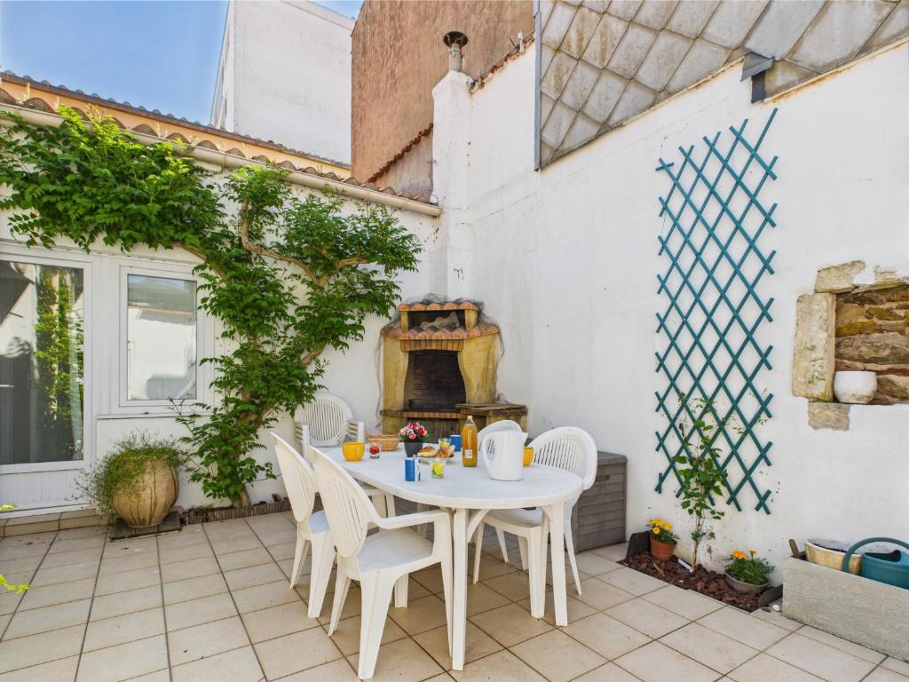d'une terrasse avec une table, des chaises et un four extérieur. dans l'établissement 200 m de la plage - Plein centre - Cour intérieure, à Les Sables-dʼOlonne