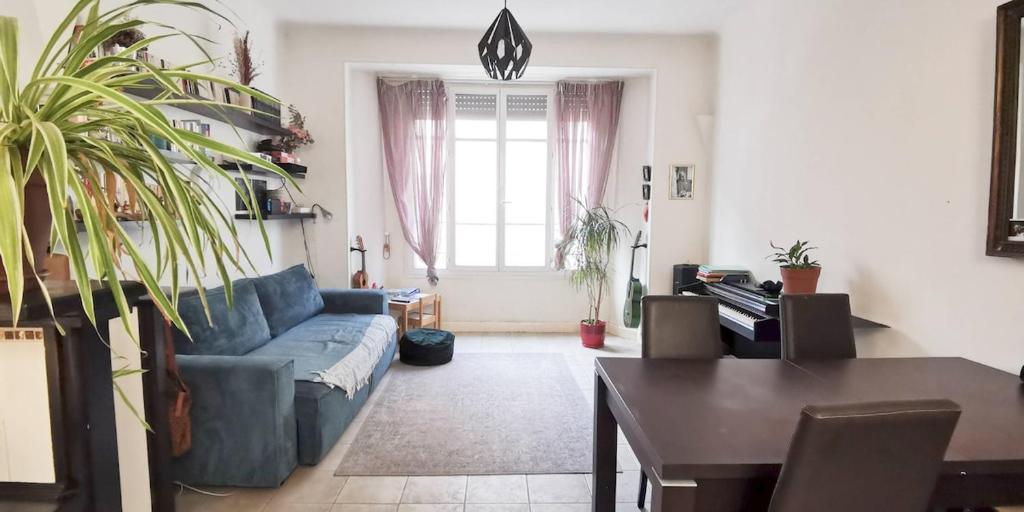 un salon avec un canapé bleu et une table dans l'établissement Appartement au coeur d'Antibes, à Antibes