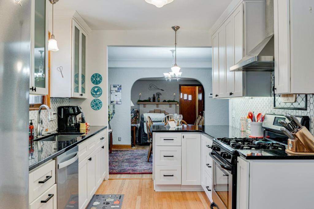 a kitchen with white cabinets and a dining room at Edina Escape in Minneapolis