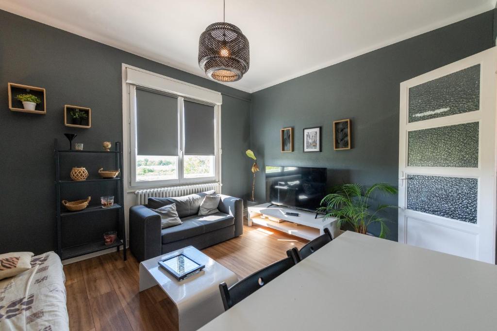 un salon avec un canapé et une table dans l'établissement La LYONNAISE - Climatisation - Proche Lyon et commodités, Transports, Tout équipé, à Grigny