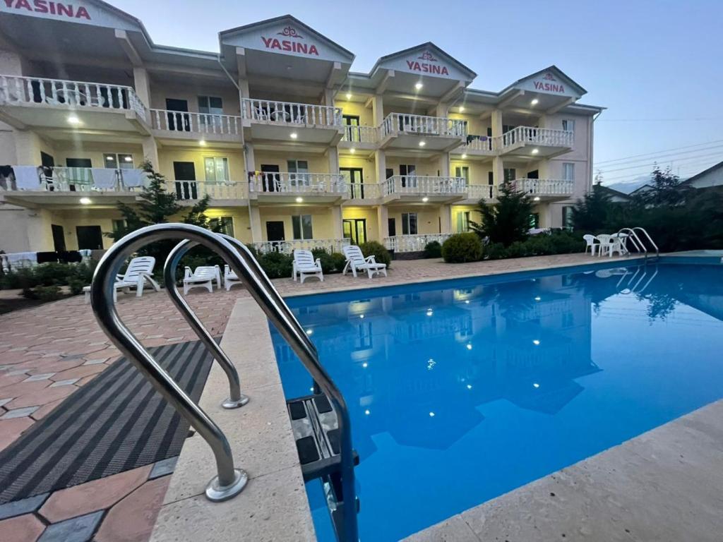a hotel with a swimming pool in front of a building at Yasina in Bosteri