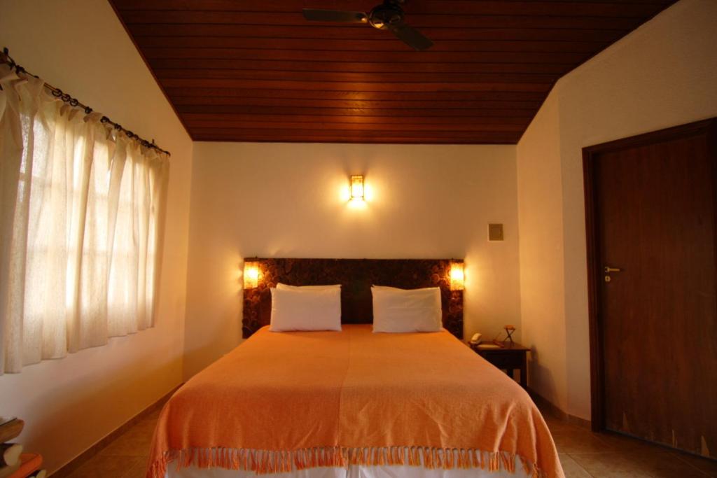 a bedroom with a large bed with two pillows at Pousada Vale das Araras in Cavalcante