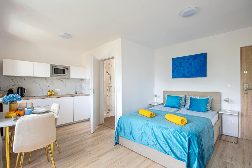 ワルシャワにあるGreen Avenue Apartments Aのベッドとテーブルとキッチンのある寝室