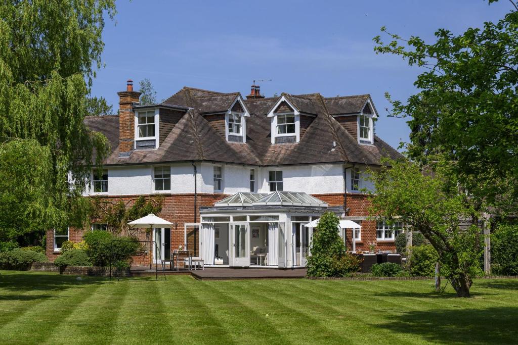 una casa grande con césped delante en Greenwood, en Brockenhurst