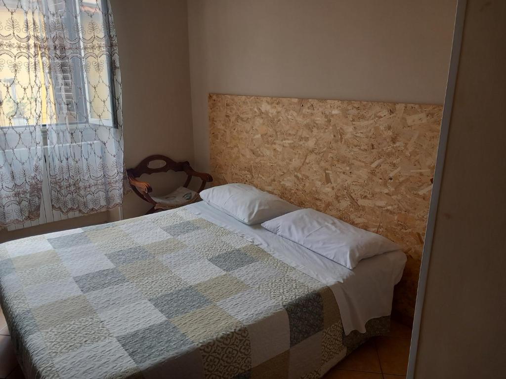 sypialnia z łóżkiem z kocem szachowym w obiekcie ACHIRINA bed and breakfast w mieście Cisterna di Latina