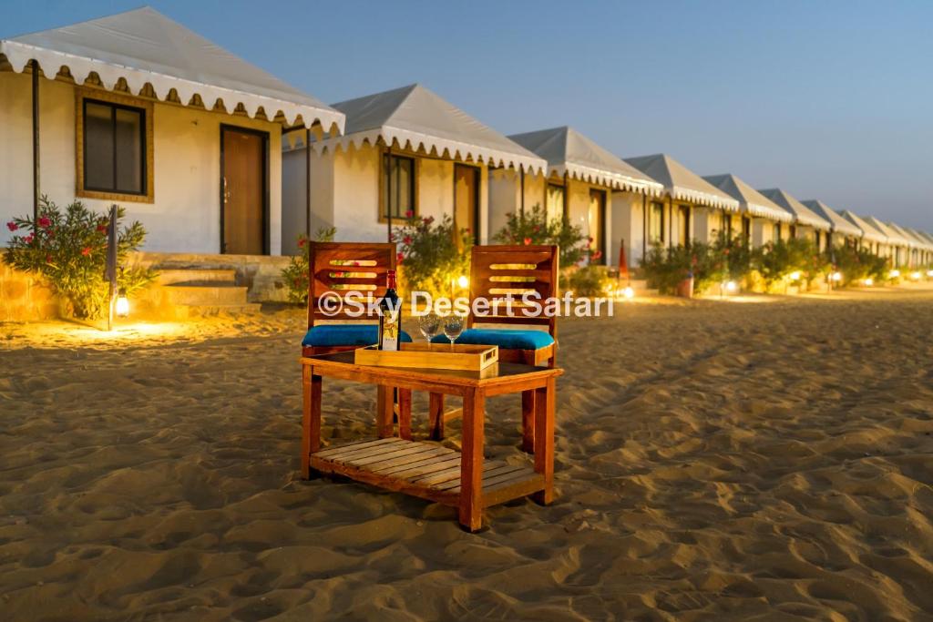 two chairs on the beach in front of a resort at Sky Desert Safari in Sām
