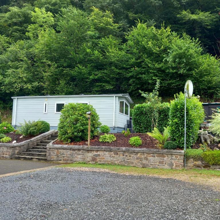 a white caravan is parked in a garden at Ferienhaus 2 Chalet in Ahrbrück
