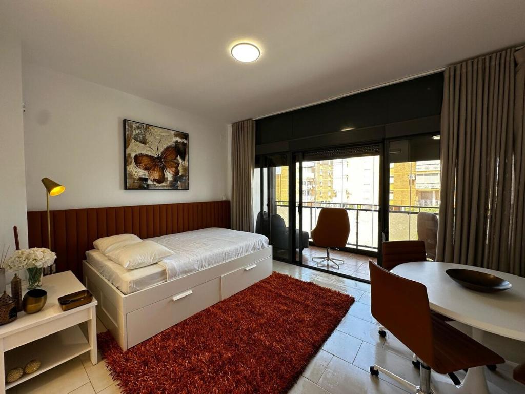 ein Schlafzimmer mit einem Bett, einem Schreibtisch und einem Tisch in der Unterkunft Magnificent Studio Isla Cristina in Isla Cristina