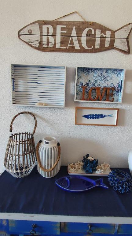 a table with plates and a fish sign on a wall at Amanecer en Cristal in Cartagena
