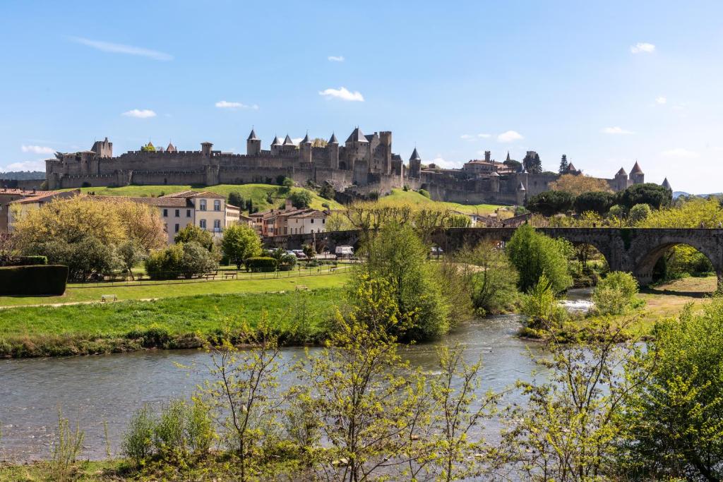 une ville avec un pont sur une rivière et un château dans l'établissement Le refuge du Gambetta - Proche Cité Médiévale & Bastide - NOUVEAU !, à Carcassonne