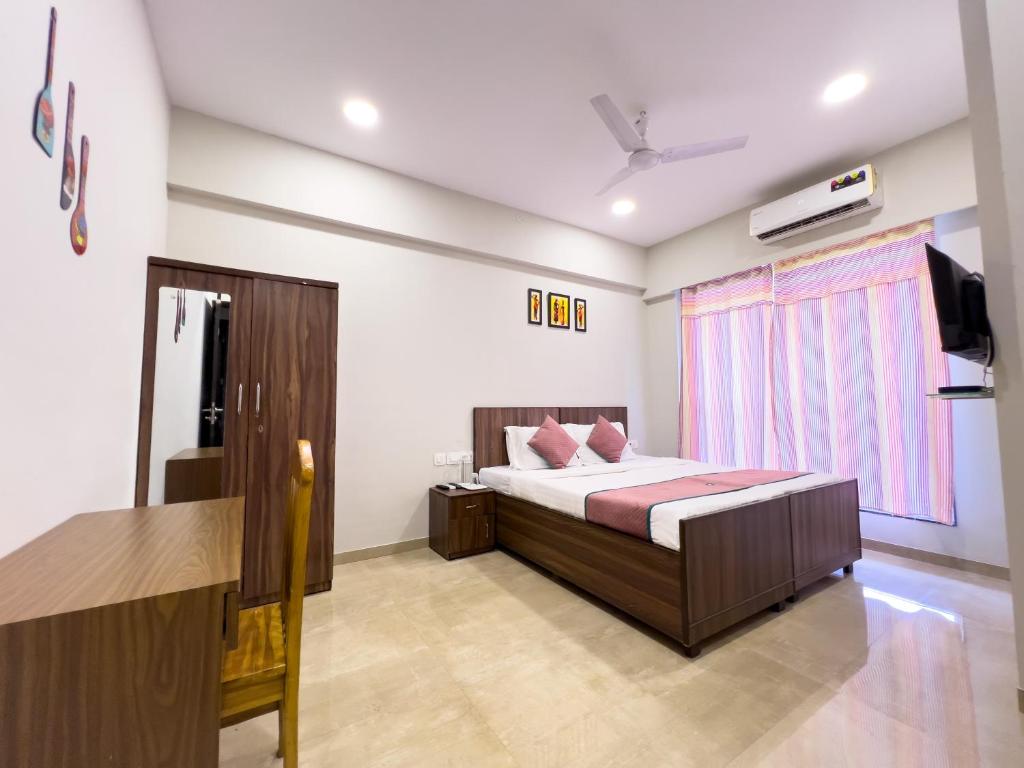 a bedroom with a bed and a window and a desk at Pinaki Comfort Stay Vile Parle - Near Airport in Mumbai