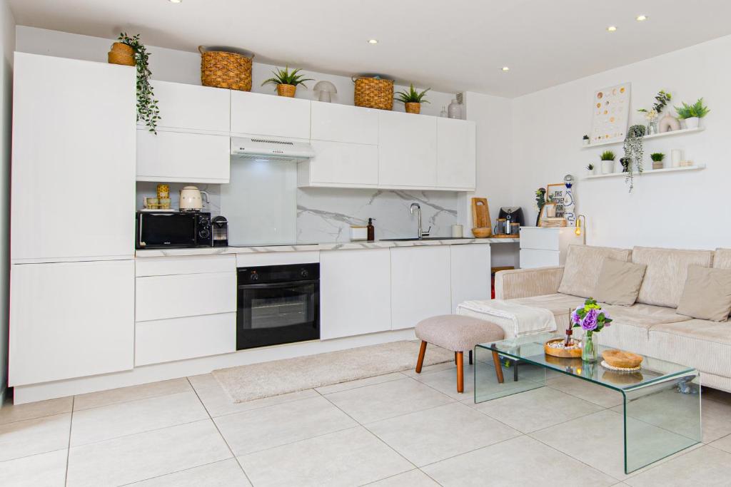 une cuisine et un salon avec un canapé et une table dans l'établissement PIERRE DE GEMMES - Agréable deux pièces - Menton - Parking Gratuit, à Menton