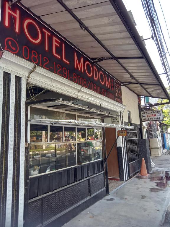 a restaurant with a sign on the side of a building at Modom Residence in Jakarta