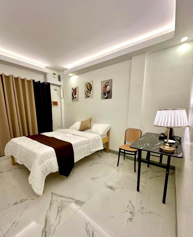 a bedroom with a bed and a table with a lamp at Casa Vina El Nido in El Nido