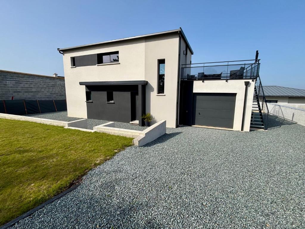une maison avec deux portes de garage dans une allée en gravier dans l'établissement Maison Ty Loki - Vue mer, 400m de la plage, à Locquirec