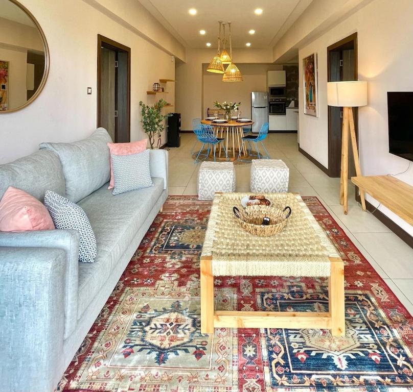 a living room with a couch and a table at The Skies by YourHost Nairobi in Nairobi