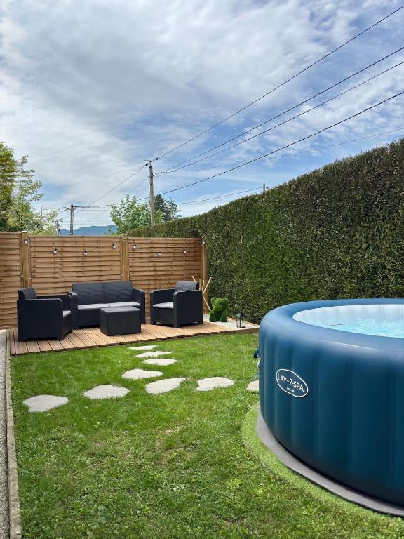 une cour avec un jacuzzi dans l'herbe dans l'établissement Villa Moussarde, à Mouxy
