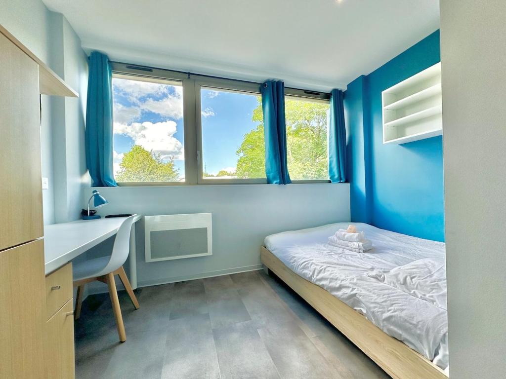 ヴァンドゥーヴル・レ・ナンシーにあるStudio 64 Rénové et Équipé - Nancy proche CHRU,CESI,FACのベッドと机と窓のある寝室