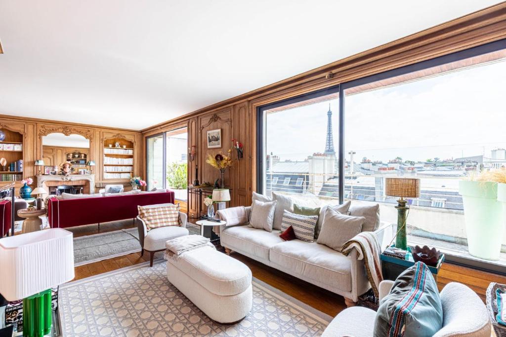Elle comprend un salon doté de meubles et d'une grande fenêtre. dans l'établissement GuestReady - Parisian Charm with Eiffel Tower View, à Paris