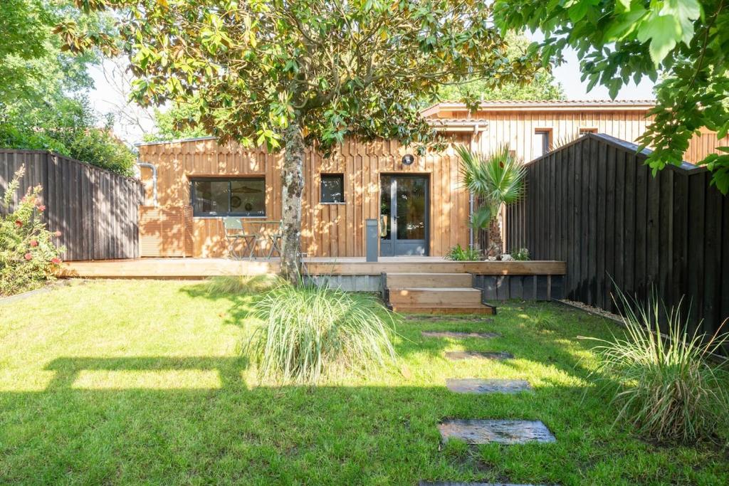 une petite maison dans une cour avec une clôture dans l'établissement Maison du Canal au bord du canal à Cazaux, à La Teste-de-Buch