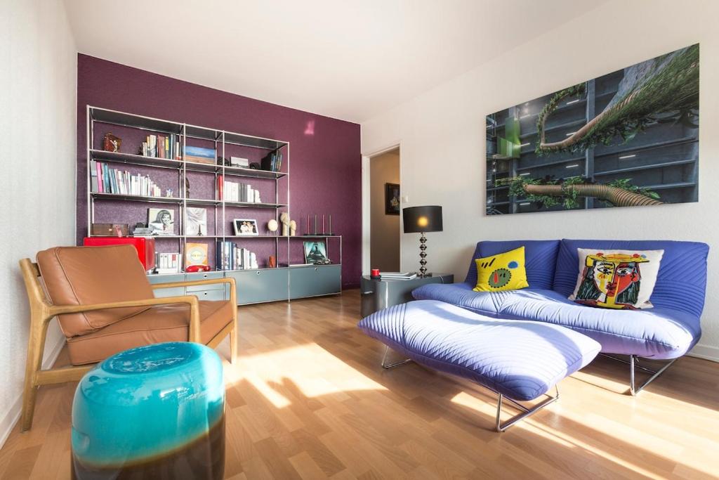 un salon avec un canapé bleu et une chaise dans l'établissement Design et calme au bord de l'eau, à Mulhouse