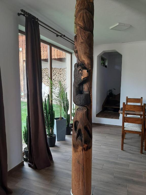 a wooden pole with a bear on it in a room at Vilmos Vendégház in Vărşag