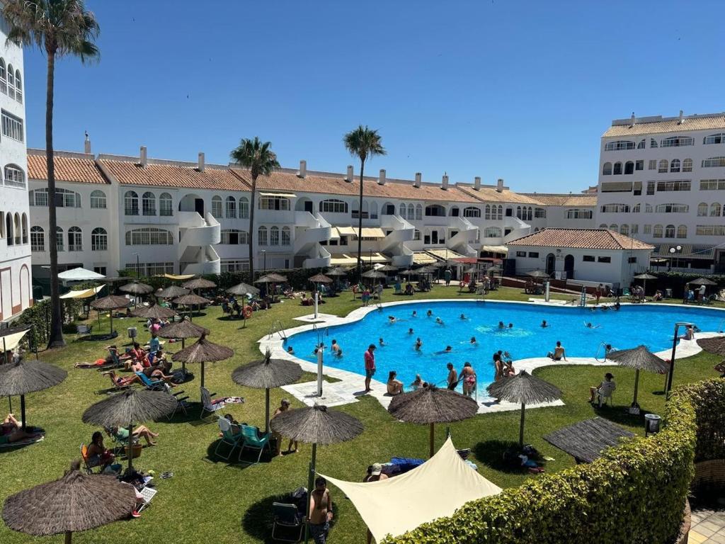 a group of people sitting around a swimming pool at La Laguna del Portil in El Portil