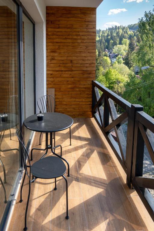 a patio with two chairs and a table on a balcony at Vila Ferdinand - Apartament Iarina in Sinaia