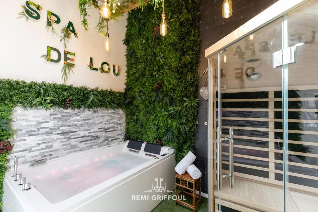 La salle de bains est pourvue d'un bain à remous avec un mur vert. dans l'établissement Le Spa de Lou Hot Tub Sauna & Private Patio 2 Guests, à Honfleur