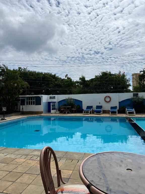 a large swimming pool with a table and chairs at Nyali Sunrise Apartment in Nyali