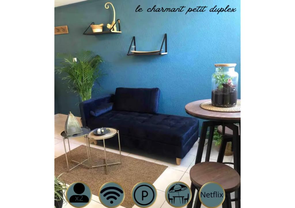 un salon bleu avec un canapé bleu et une table dans l'établissement Charmant petit duplex, à Montpellier