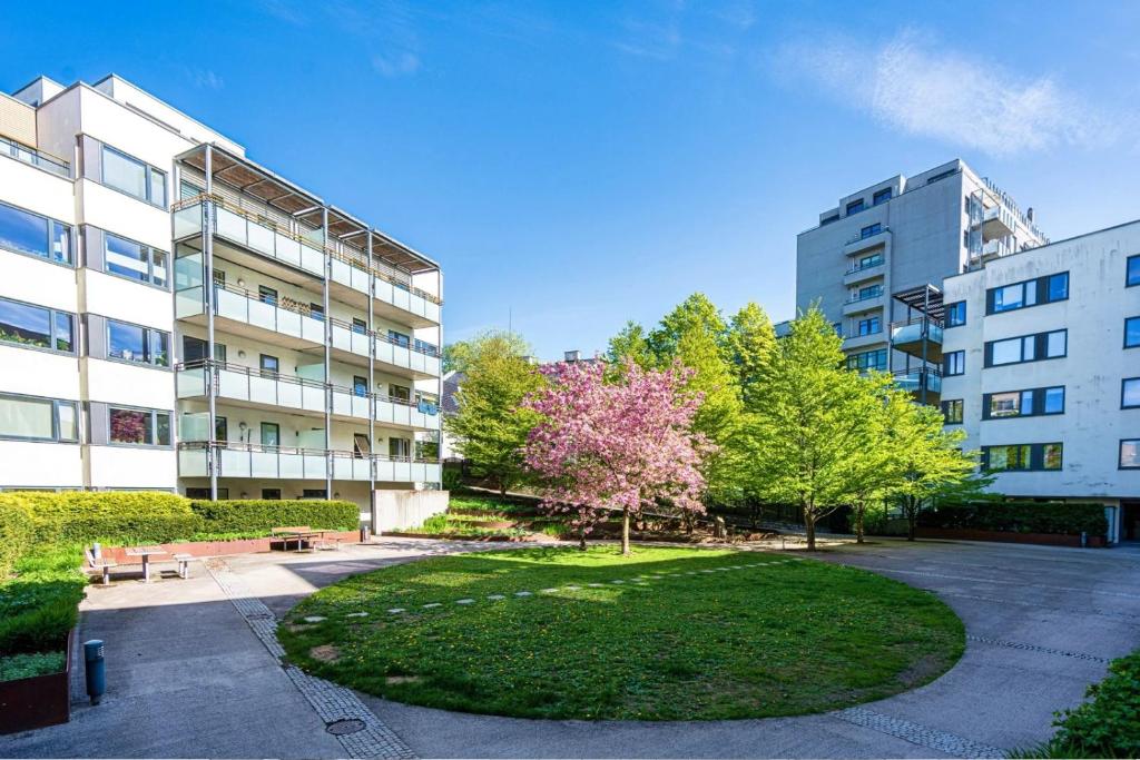 a park in front of a building with a tree at PP1b-Central-Cosy studio flat Suits globetrotters in Oslo
