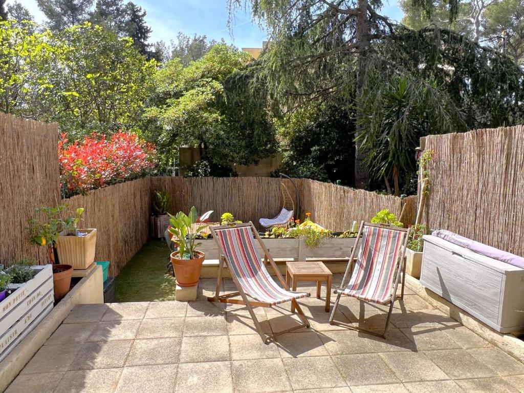 un patio avec deux chaises et une table avec des plantes dans l'établissement Le Costabella - Appartement pour 4 personnes à 5 minutes de la plage de l'Almanarre à Hyères, à Hyères