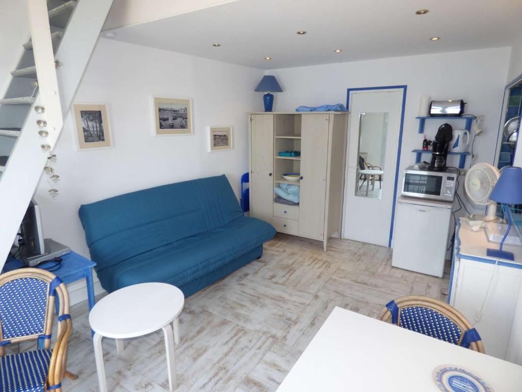 un salon avec un canapé bleu et une cuisine dans l'établissement Rare à la location, pieds dans l' eau, pleine vue mer, wifi ..., à La Seyne-sur-Mer