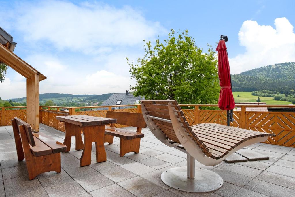 a patio with a table and chairs and an umbrella at Schonzeit Chalet in Bernau im Schwarzwald