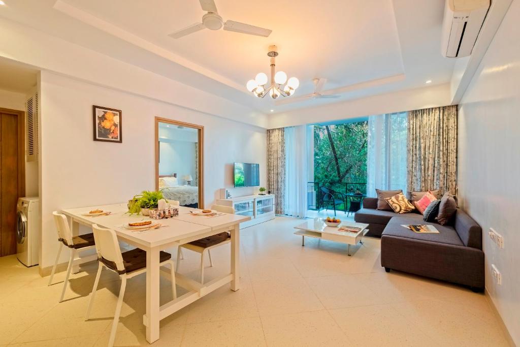 a living room with a table and a couch at Brand New Luxury 1BHK Apartment by tisyastays in Candolim