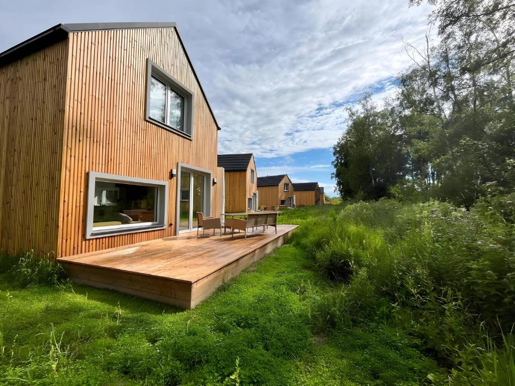 a wooden deck on the side of a house at Nadmorski Spokój, domki i sauna in Lubiatowo