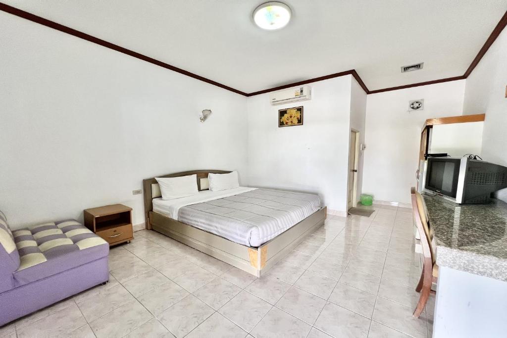 Un dormitorio con una cama, un sofá y un televisor. en Paradise Resort Buriram, en Buriram